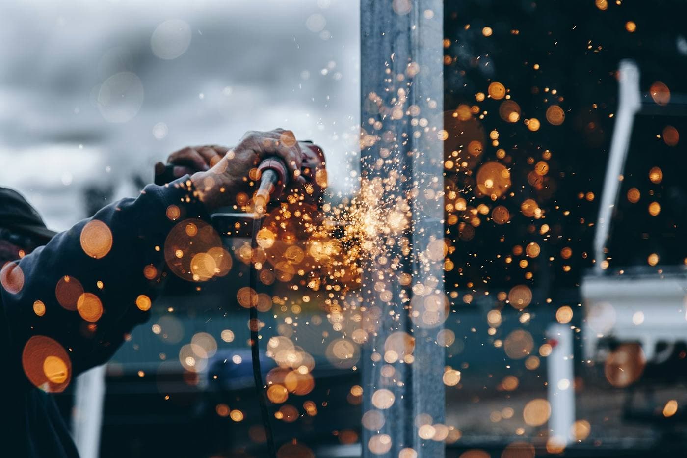 Welder at work with bright sparks in an industrial workshop